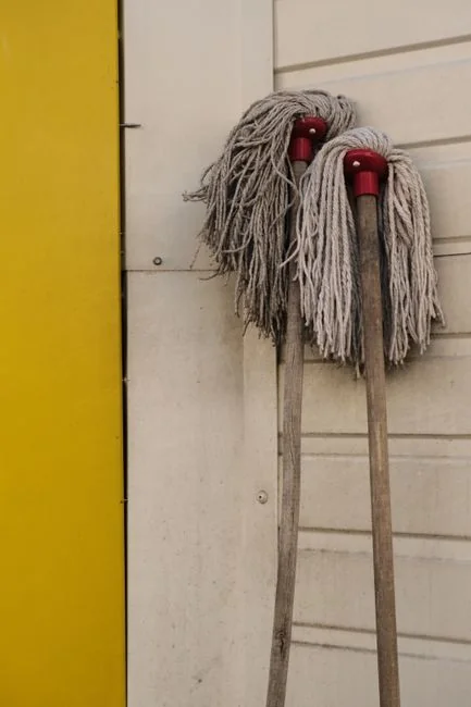 A couple collaboratively lifting a couch while moving into a new apartment.